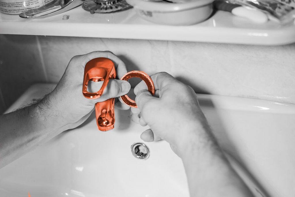Person fixing a leaky faucet